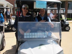 Matt Sinnett in golf cart with Darrell Harke
