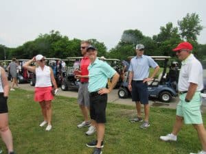 Golfers in golf cart at MIB golf event