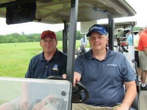 Golfers in golf cart at MIB golf event